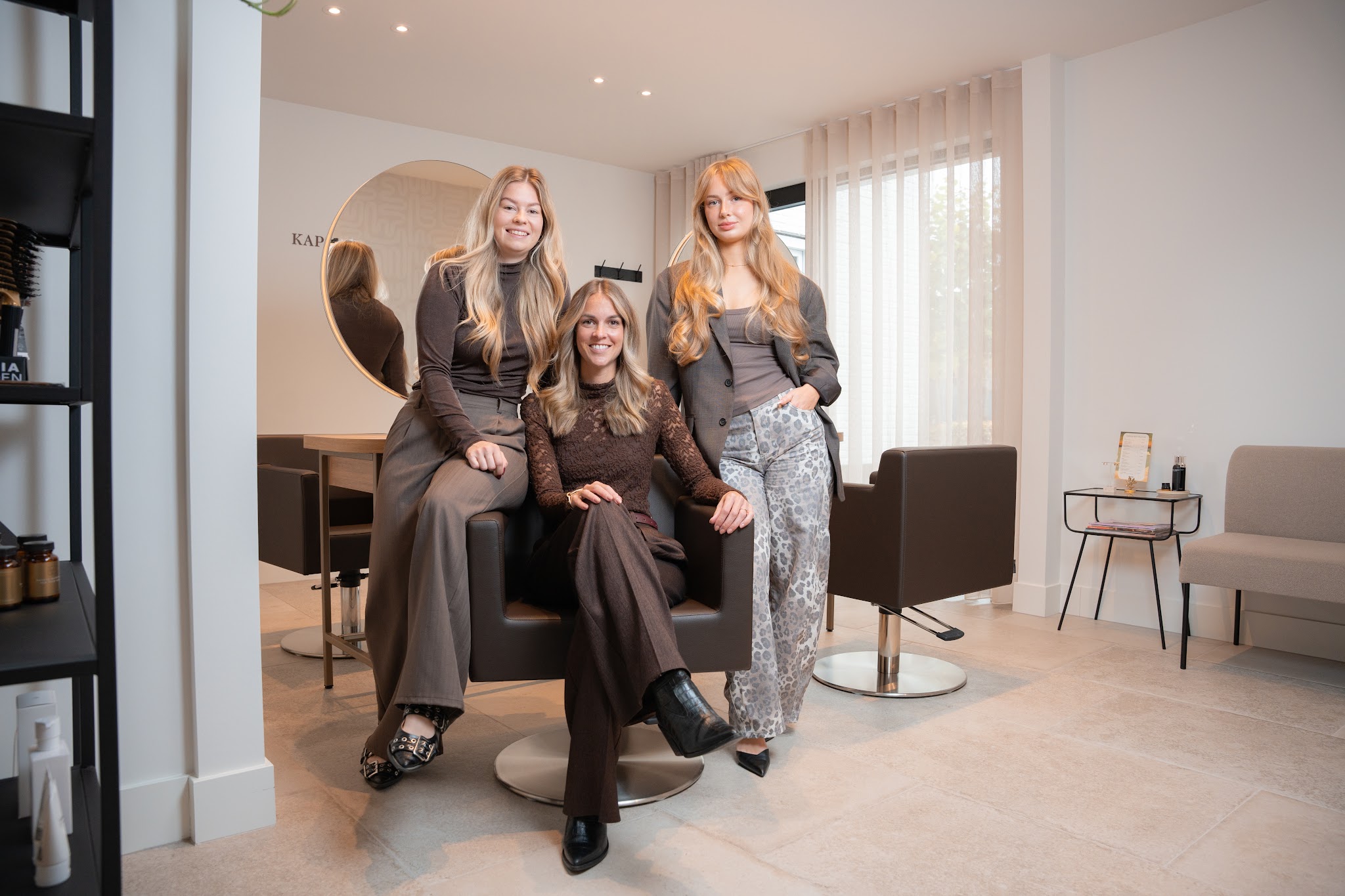 Daniëlla met haar team in de salon aan De Splinter Kreek, tussen de ronde spiegels en de bruine stoelen
